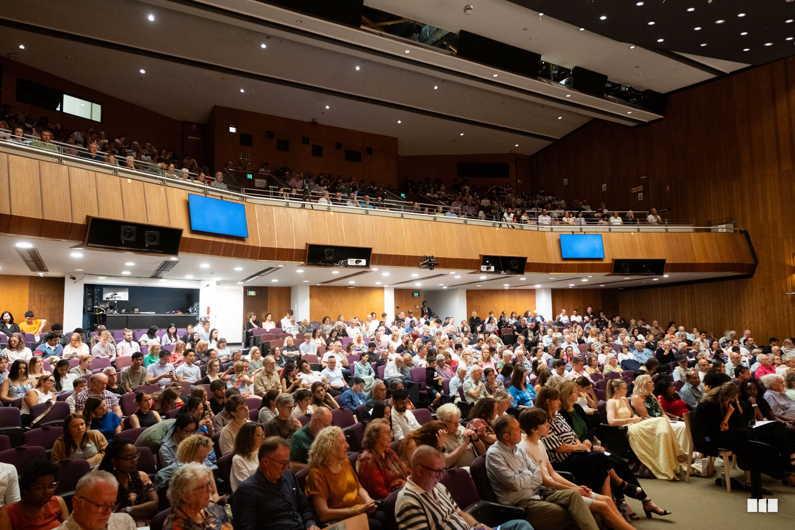 A large audience fills the auditorium seats during a performance at the venue.