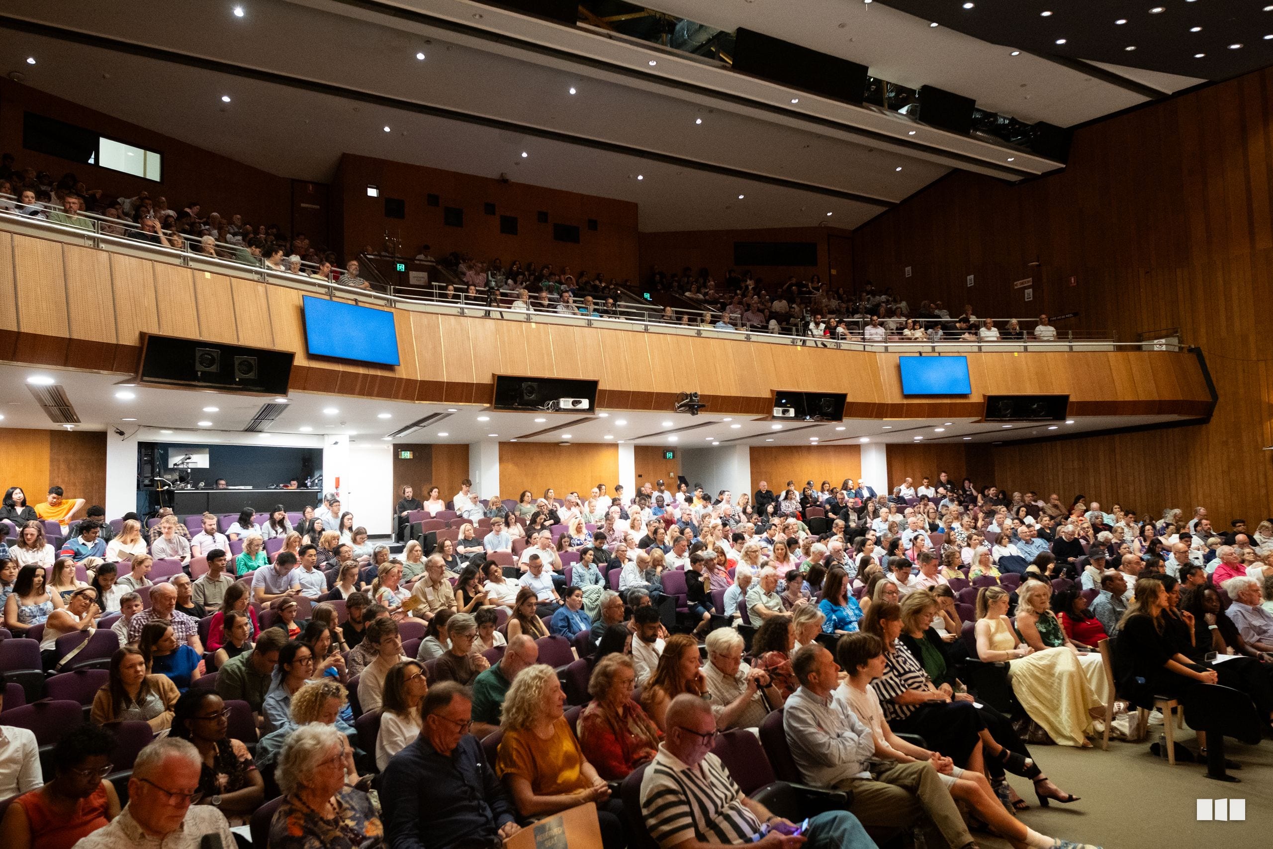 A large audience fills the lecture hall during an Australian Christian Arts event.
