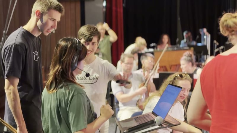 Young musicians and audience members participate in an interactive workshop or rehearsal session on stage.