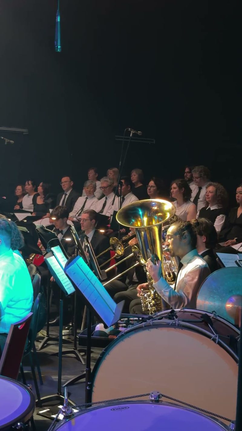 A symphony orchestra and choir performing together on stage.