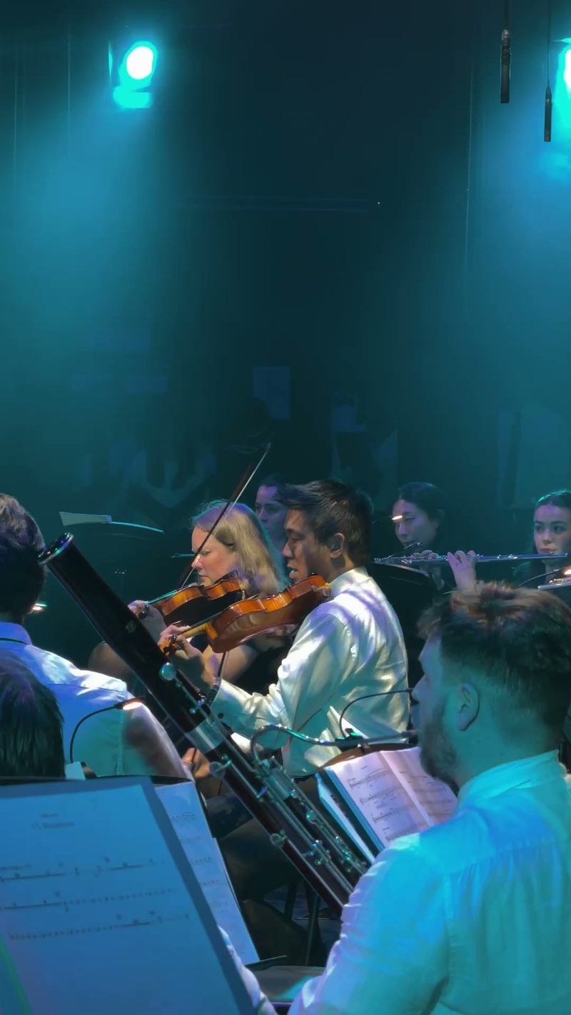 A group of musicians performing together in a dimly lit venue.
