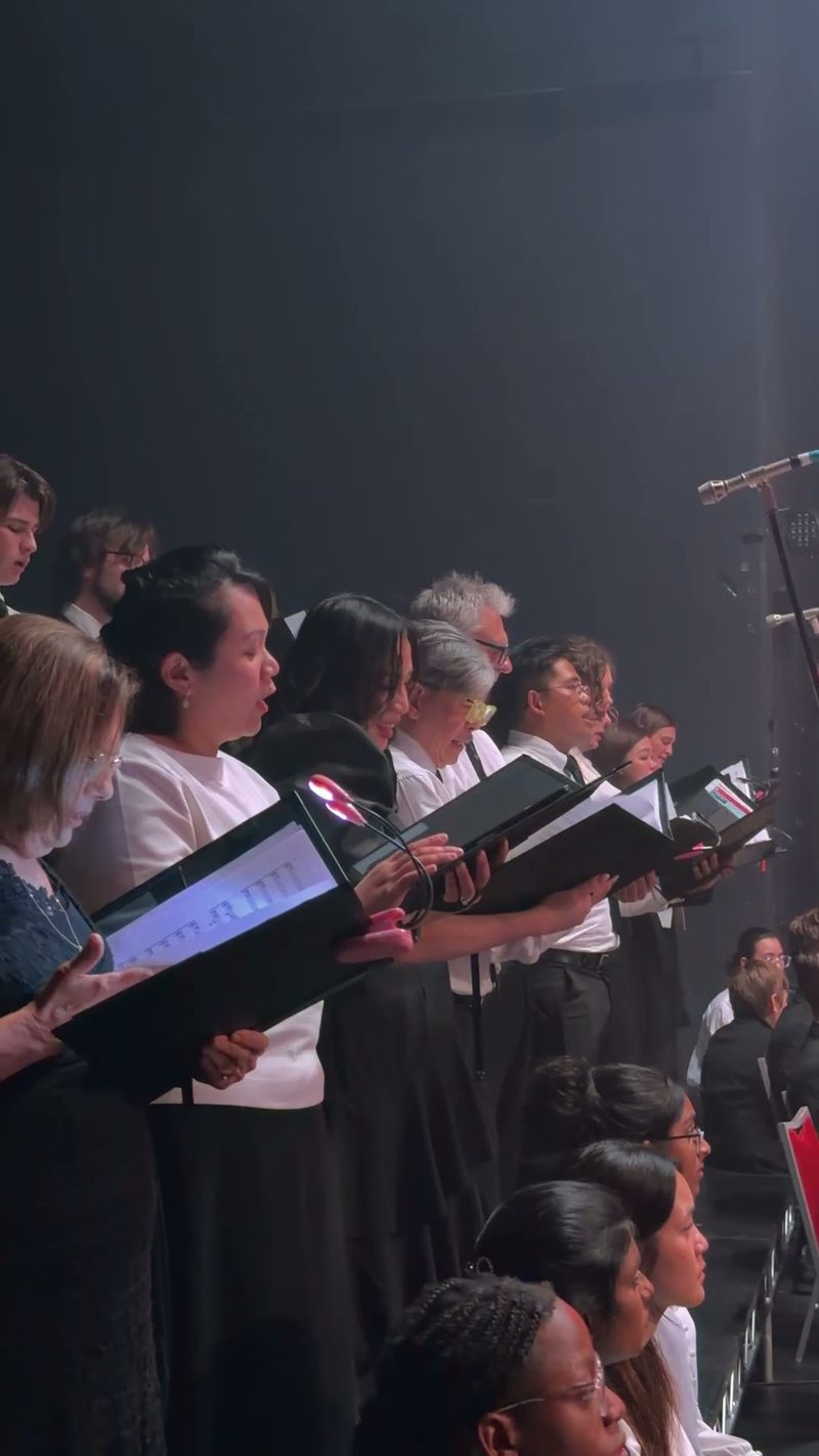 A choir performing with sheet music in hand.