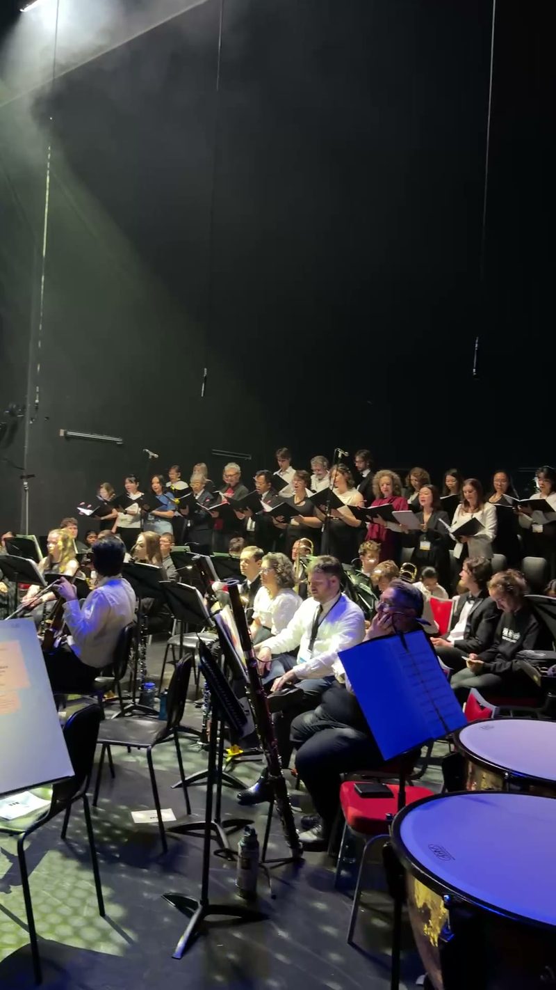 A choir performing on stage with musicians in the foreground.