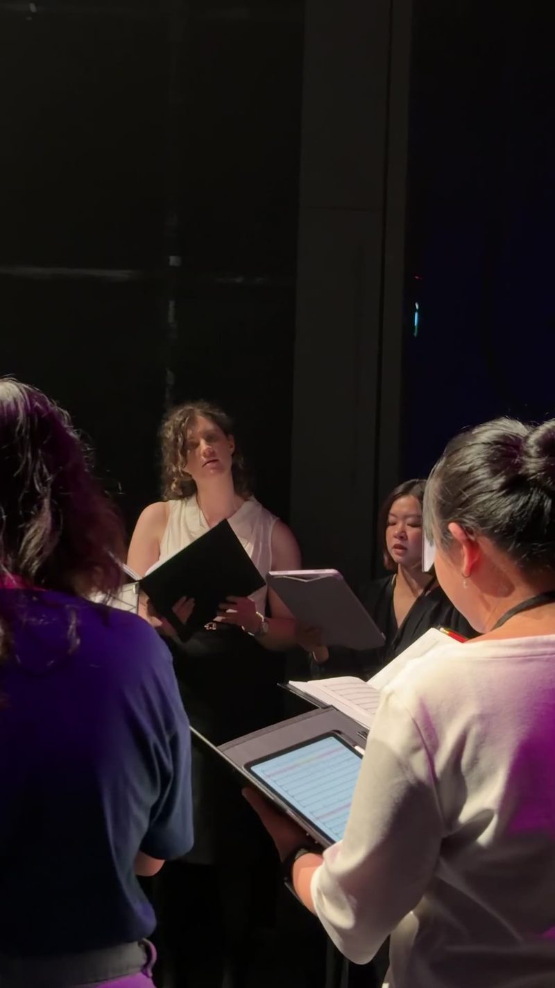 A group of singers rehearsing on stage.